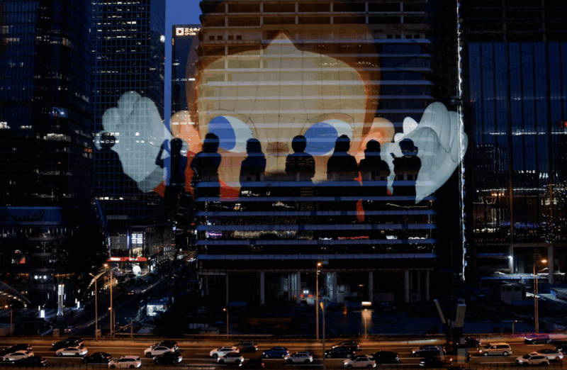 The reflection of silhouettes of people is visible on a glass on a terrace of a shopping mall overlooking Beijing's central business district (CBD), China , August 11, 2025. REUTERS/Tingshu Wang Purchase Licensing Rights